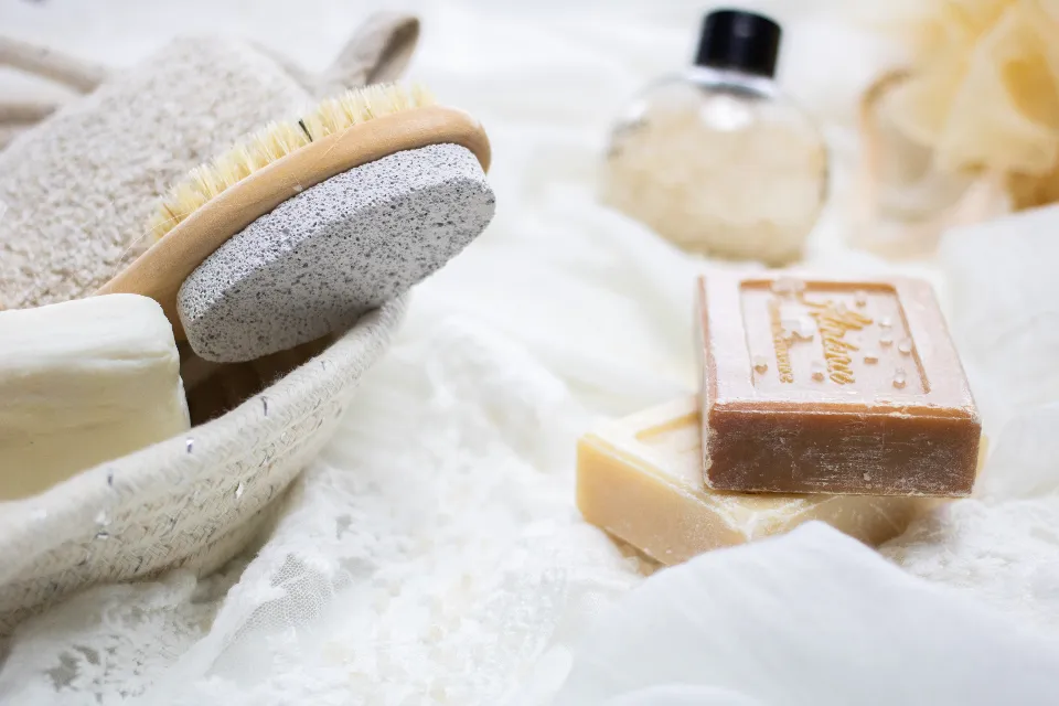 Natural soap bars and wooden bath brush in a cotton basket